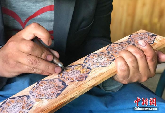 图为7月14日,普松雕刻技艺传承人嘎玛曲扎正在家中进行创作。 <a target='_blank' href='http://www.chinanews.com/'><p align=