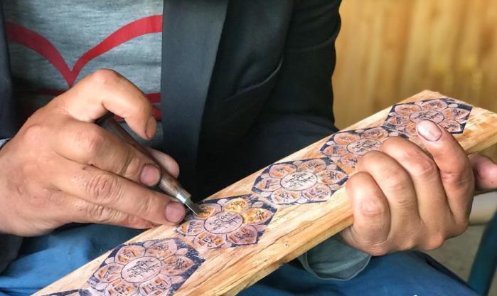 图为7月14日，普松雕刻技艺传承人嘎玛曲扎正在家中进行创作。 <a target='_blank' href='http://www.chinanews.com/'><p  align=