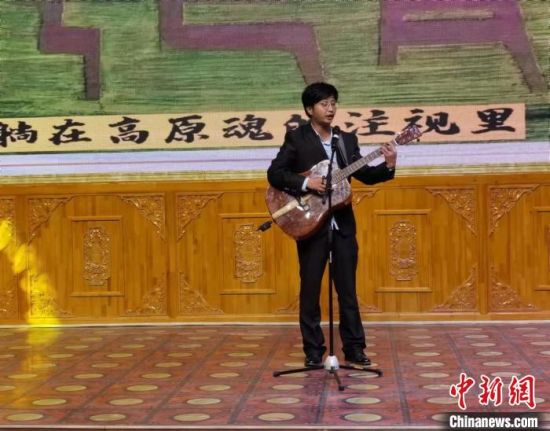 图为刘雷手抱吉他,在舞台上演唱自创歌曲《忆羚》。(资料图) 张婧 摄