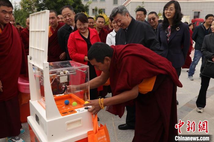 图为青海省藏语系佛学院学生现场体验科普器材。　青海省委统战部供图