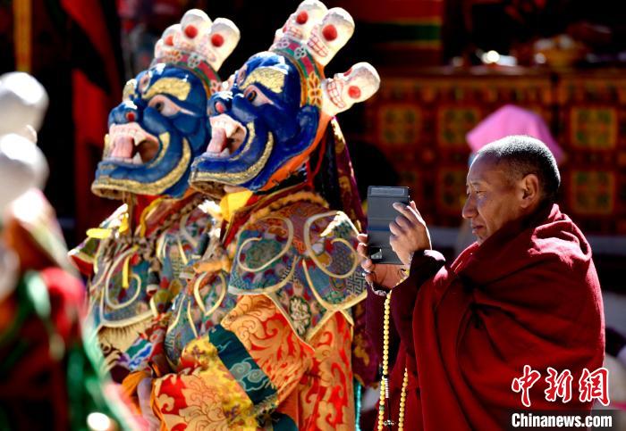 2月19日,正在拍摄跳神活动的僧人。 李林 摄