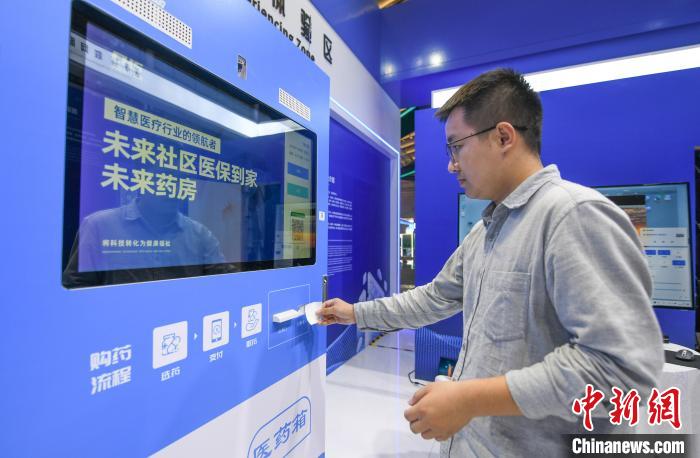 在“中国医保 一生守护”展区，民众体验在24小时未来药房凭“处方”取药 王刚 摄